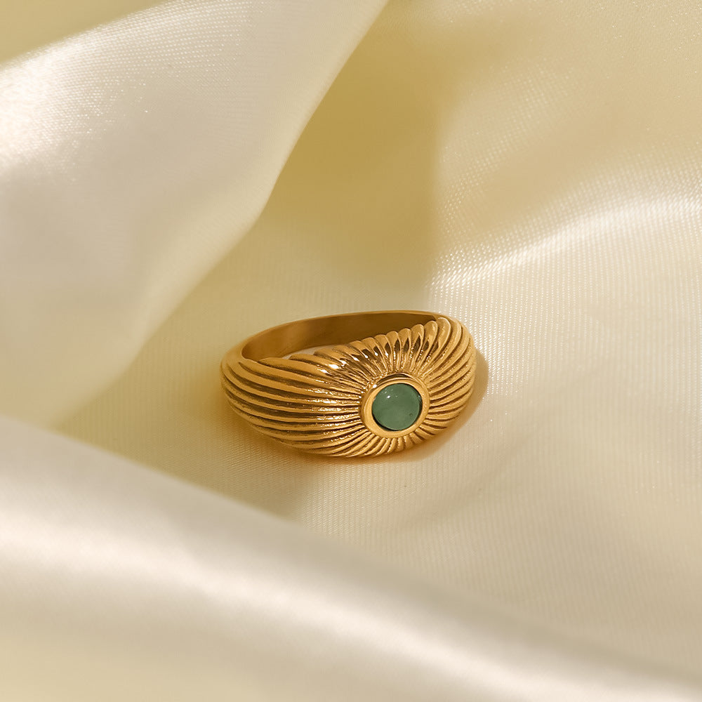 18K Gold Plated Green Stone Sun Ring displayed on satin fabric, featuring a sun-shaped design with a green stone.